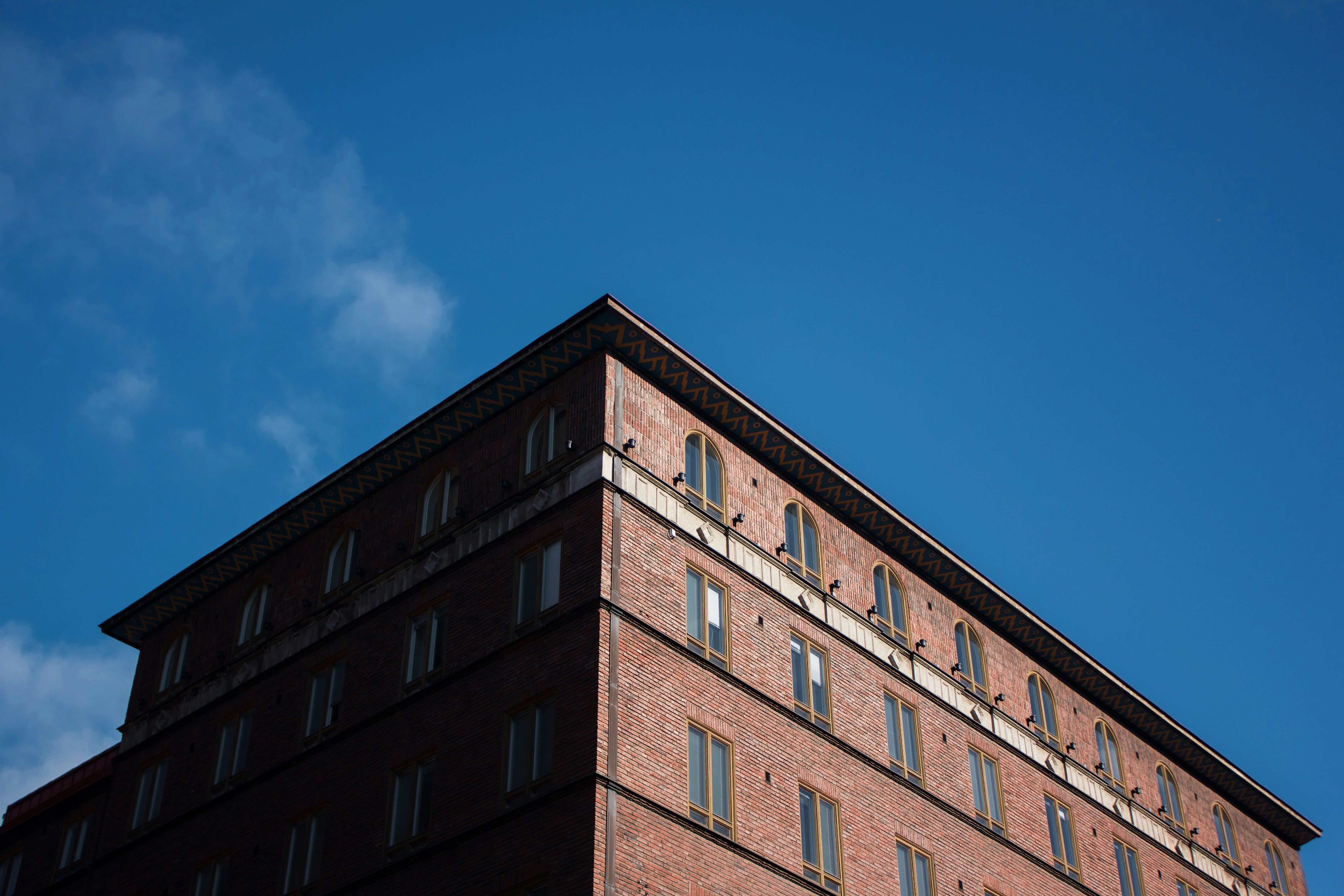 low-angle photo of brown building under blue sky